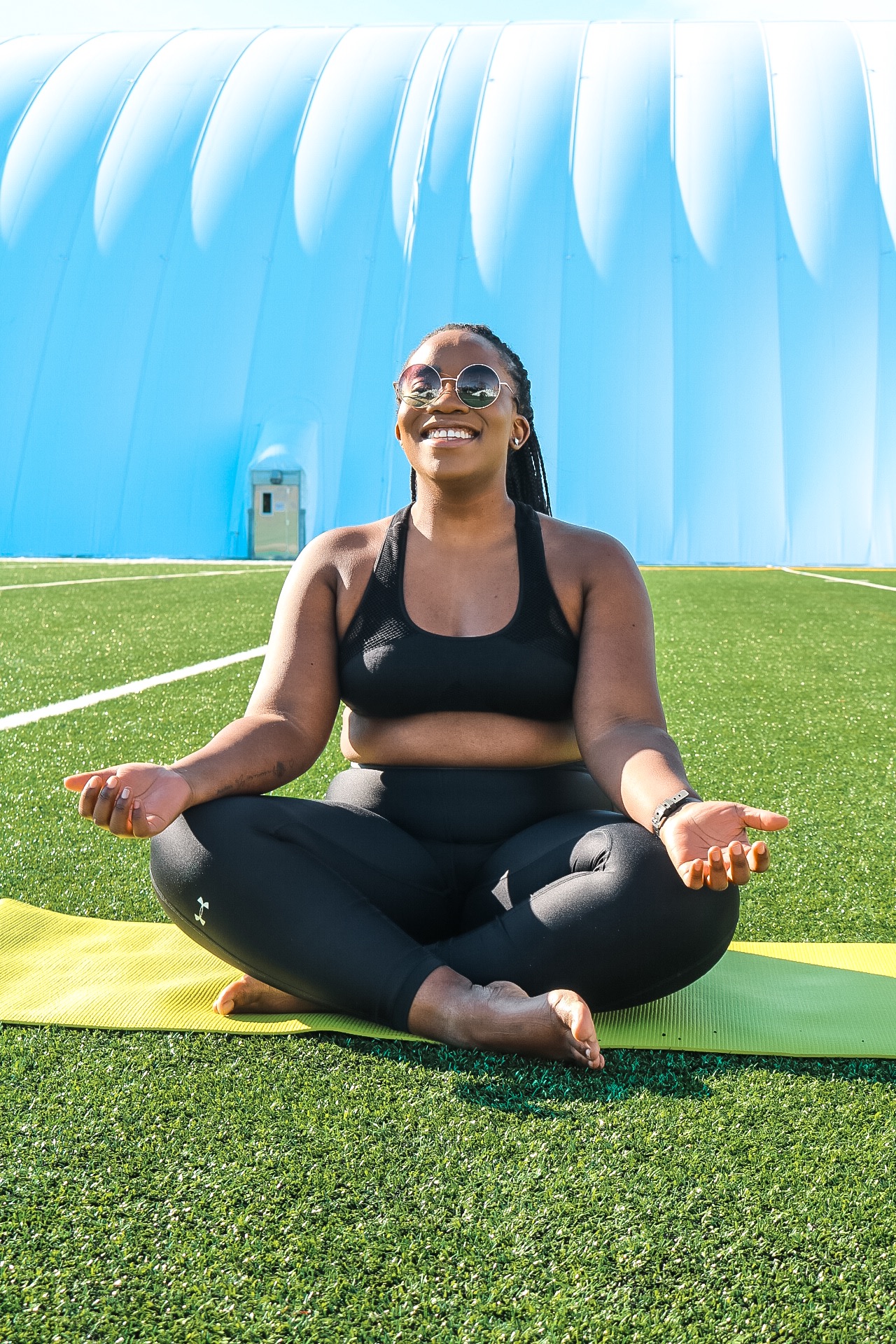 Boston blogger Binja on a yoga mat in a  pose in under armor workout gear 