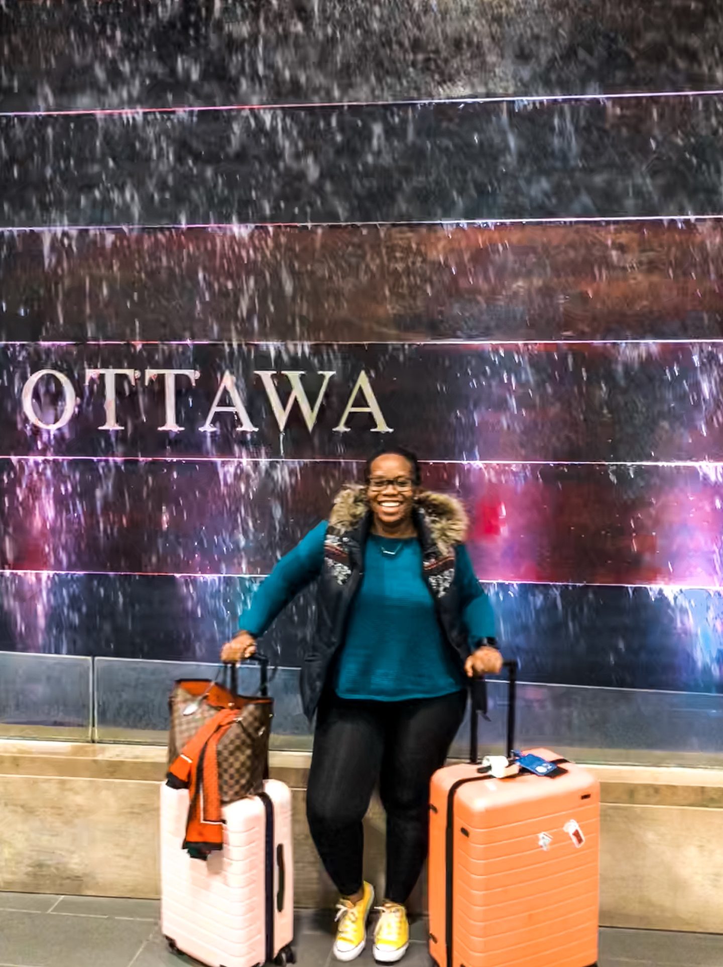 African blogger based in Boston Binja the Africancocktail in front of Ottawa sign in Canada