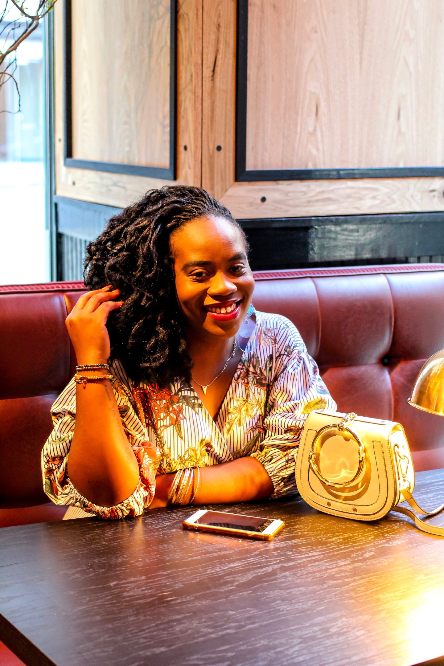 Image shows Boston based African blogger Binja Sitting  at a table at Tradesman cafe in Boston